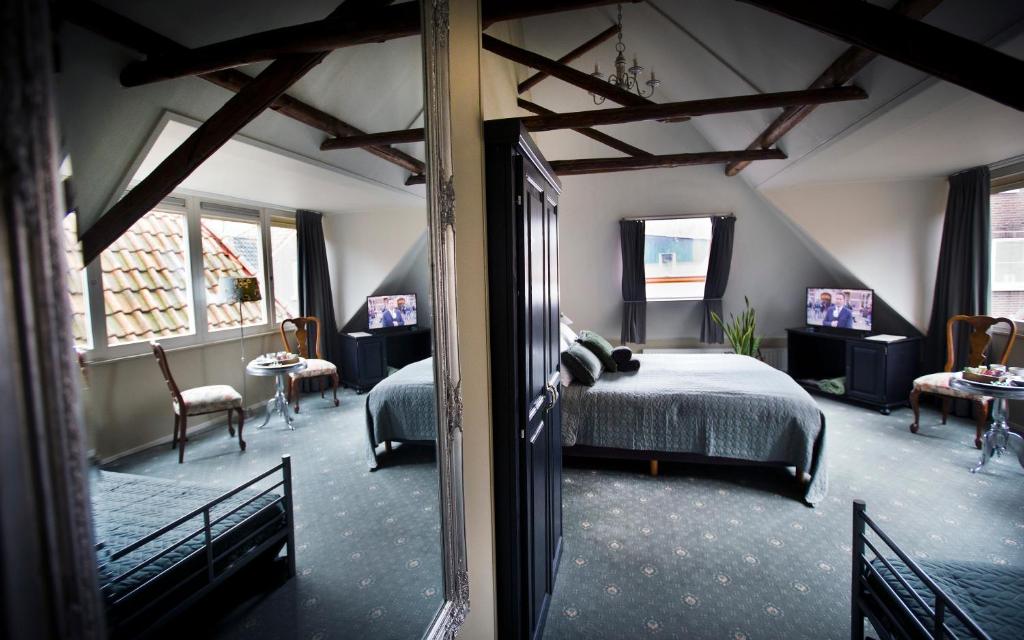 een slaapkamer met een bed en een woonkamer bij Stadslogement De Oude Smidse Steenwijk in Steenwijk