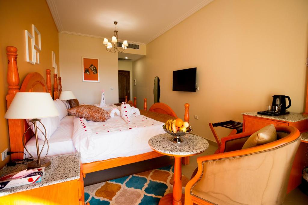 a bedroom with a bed and a table and a chair at Holy Family Hotel in Jabal aţ Ţayr