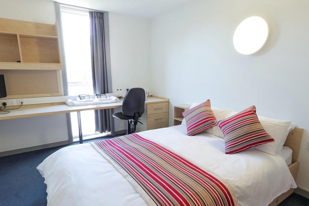 um quarto com uma cama com duas almofadas em Keynes College em Canterbury
