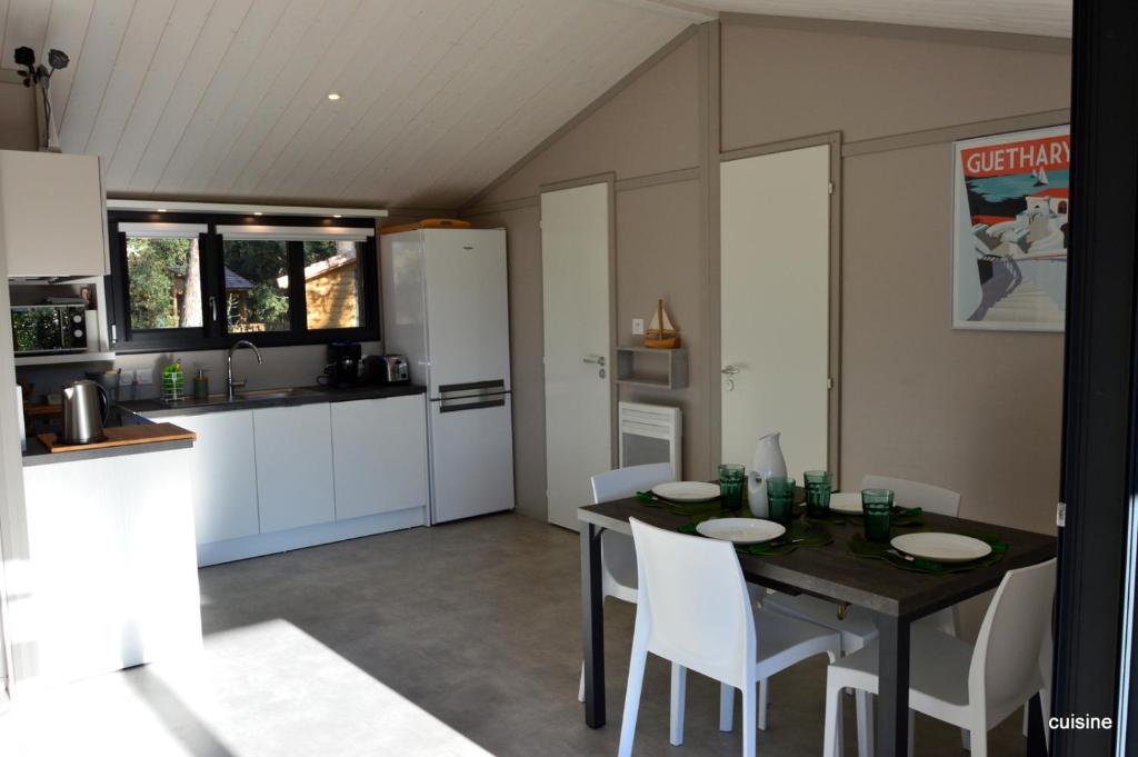 a kitchen and dining room with a table and chairs at Chalet la lande in Ondres