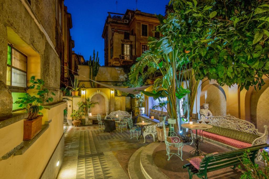 a courtyard with tables and chairs in a building at Hotel Emona Aquaeductus in Rome