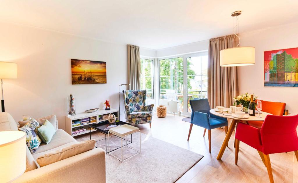 uma sala de estar com um sofá, uma mesa e cadeiras em Strandallee 200 - App. 309 em Timmendorfer Strand