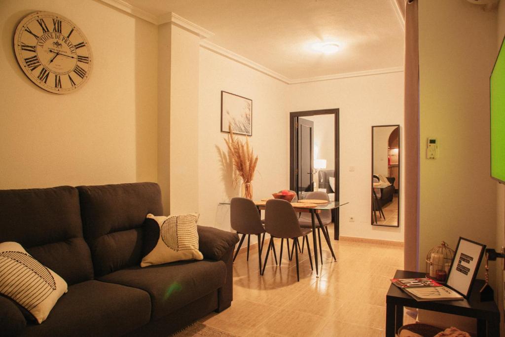 a living room with a couch and a clock on the wall at Aparthotel Costa Blanca in Torrevieja