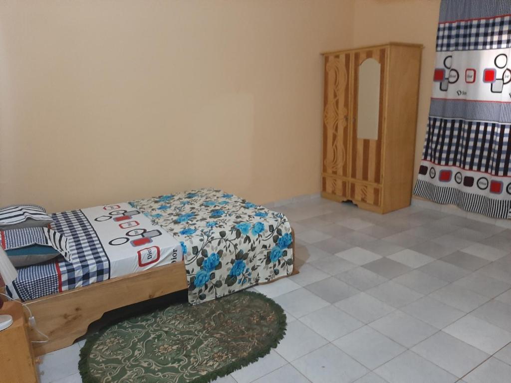 Dormitorio pequeño con cama y alfombra en Villa Chambre A climatisée douche Cuisine salon en Bamako