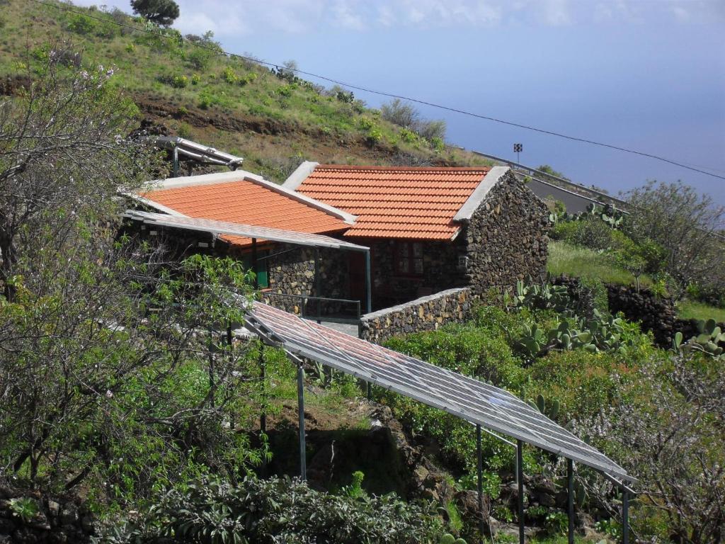 una casa al lado de una colina con un panel solar en Casa Rural Abuelo Pancho, en Las Casas