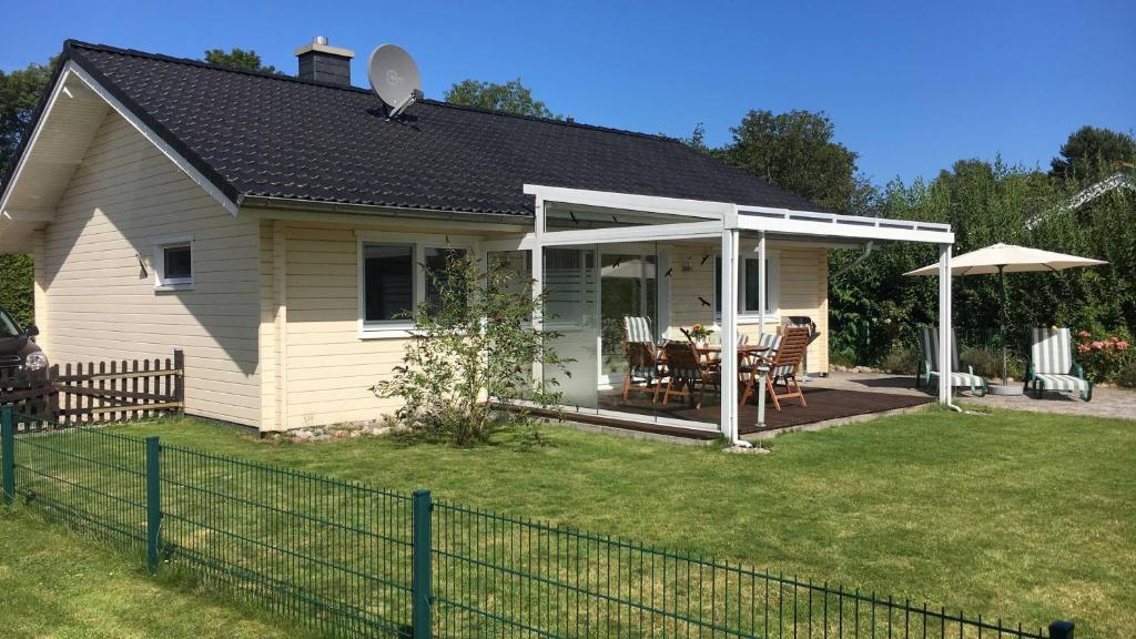 a house with a patio with a table and an umbrella at _BIR14_ Haus am Birkenweg in Niendorf