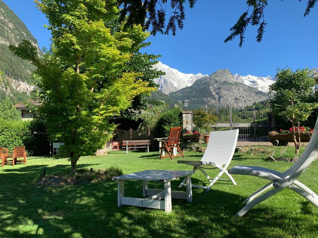 a chair and a table in a yard with mountains at Hameau De Jadis in Pré-Saint-Didier