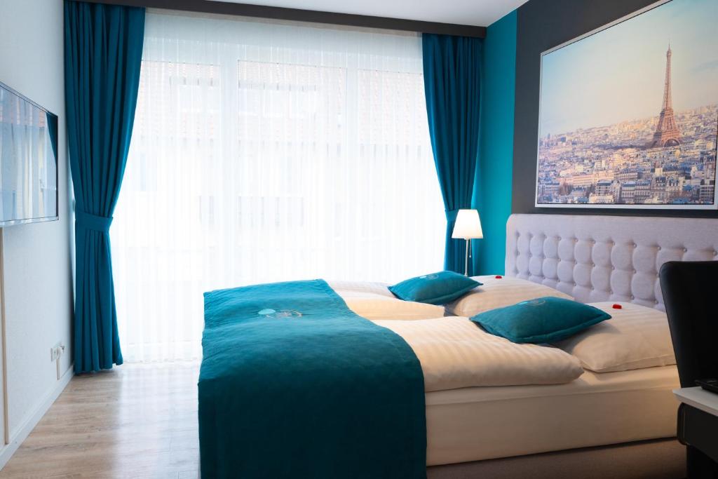 a bedroom with a large bed with a large window at Friends Hotel Bad Salzuflen in Bad Salzuflen