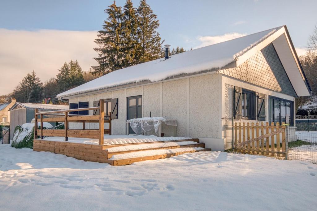 ein Haus mit einer Terrasse im Schnee in der Unterkunft Gentiane in Saint-Amandin