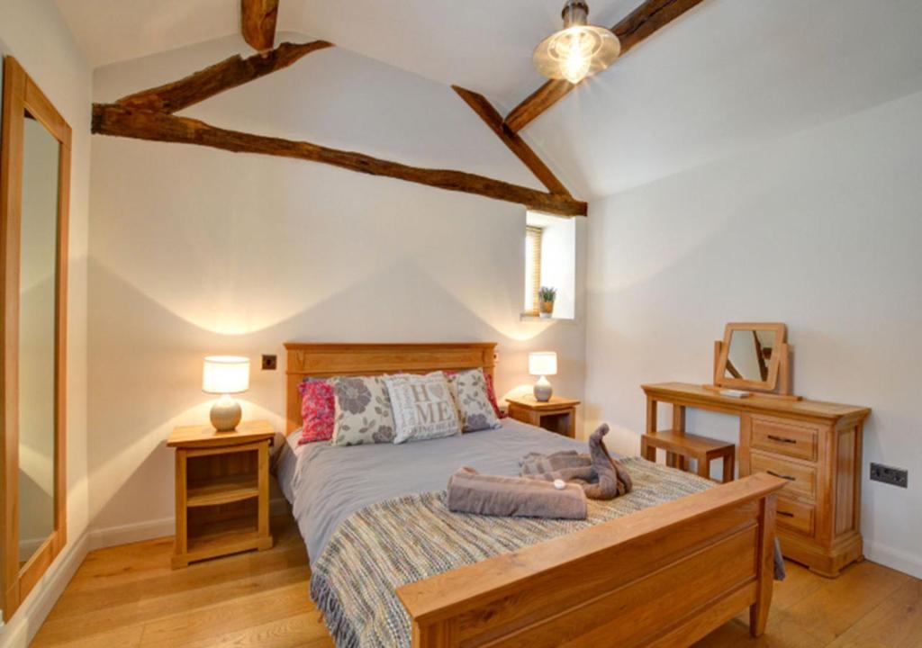 a bedroom with a bed and two night stands and two lamps at Smithy Cottage in Berriew