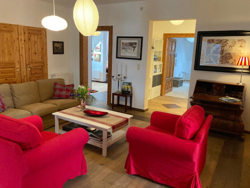 un soggiorno con tavolo e sedie rosse di Auberge Tabarz Inselsberg a Tabarz