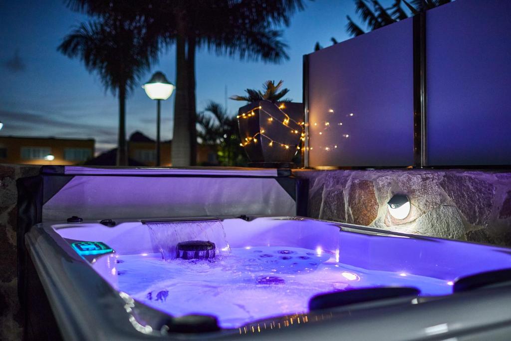 a bath tub with purple lighting in front of a building at Villa Gisel in La Playa de Tauro