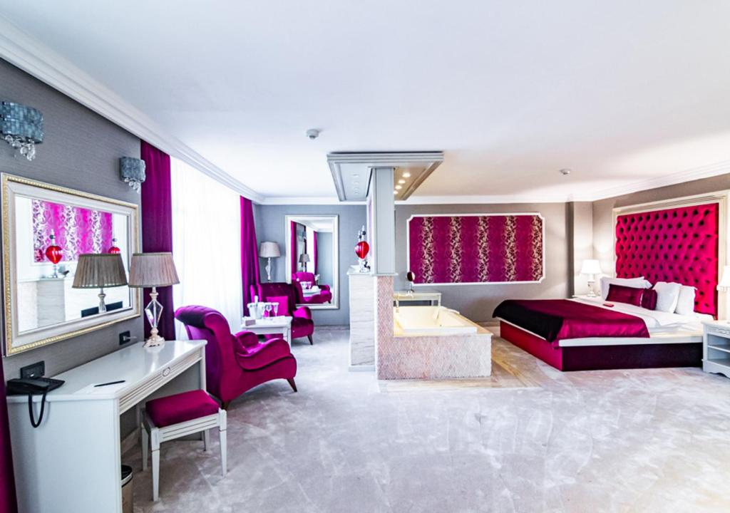 ブカレストにあるフェニシア グランド ホテルのベッド、デスク、椅子が備わるホテルルームです。