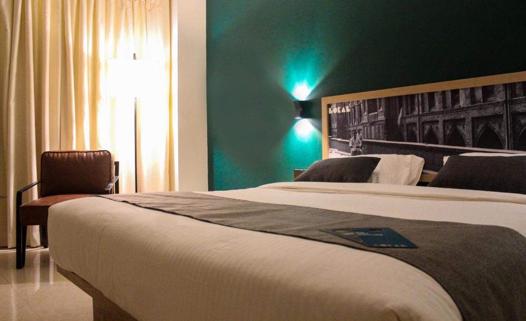 ein Hotelzimmer mit 2 Betten und einer grünen Wand in der Unterkunft LOKAL Rooms x Gulberg in Lahore