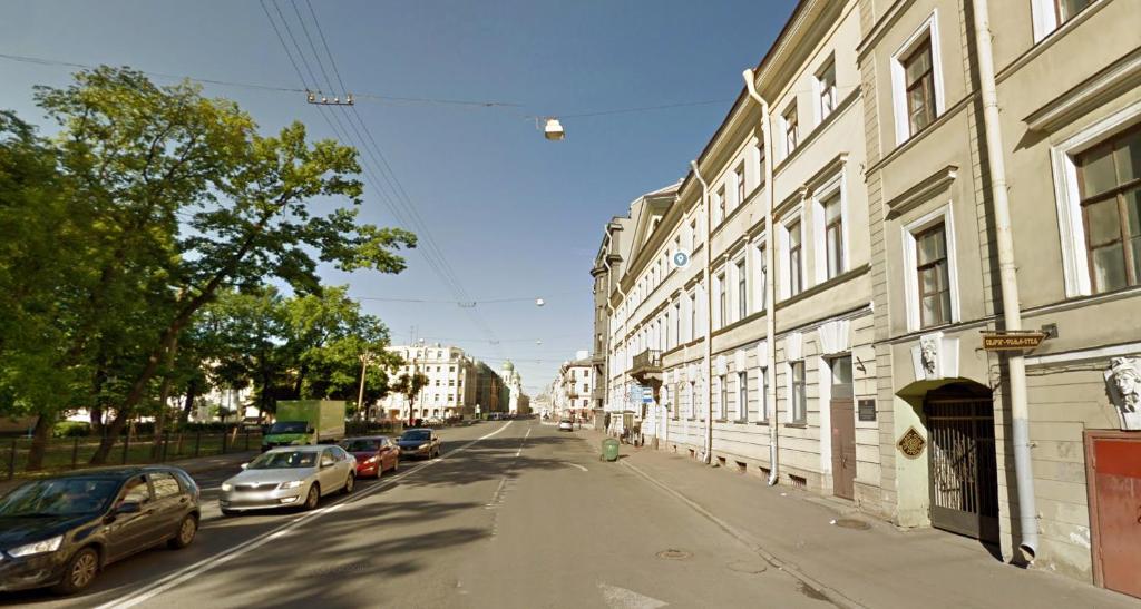 a street with cars parked on the side of a building at Svarog Film Hotel in Saint Petersburg