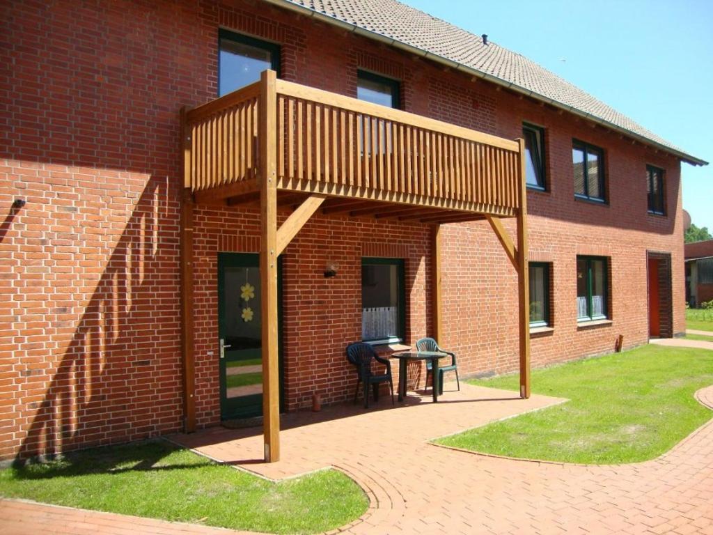 een houten pergola aan de zijkant van een bakstenen gebouw bij Sterne-Anlage HOF NIEMEYER Steinhuder Meer in Neustadt am Rübenberge