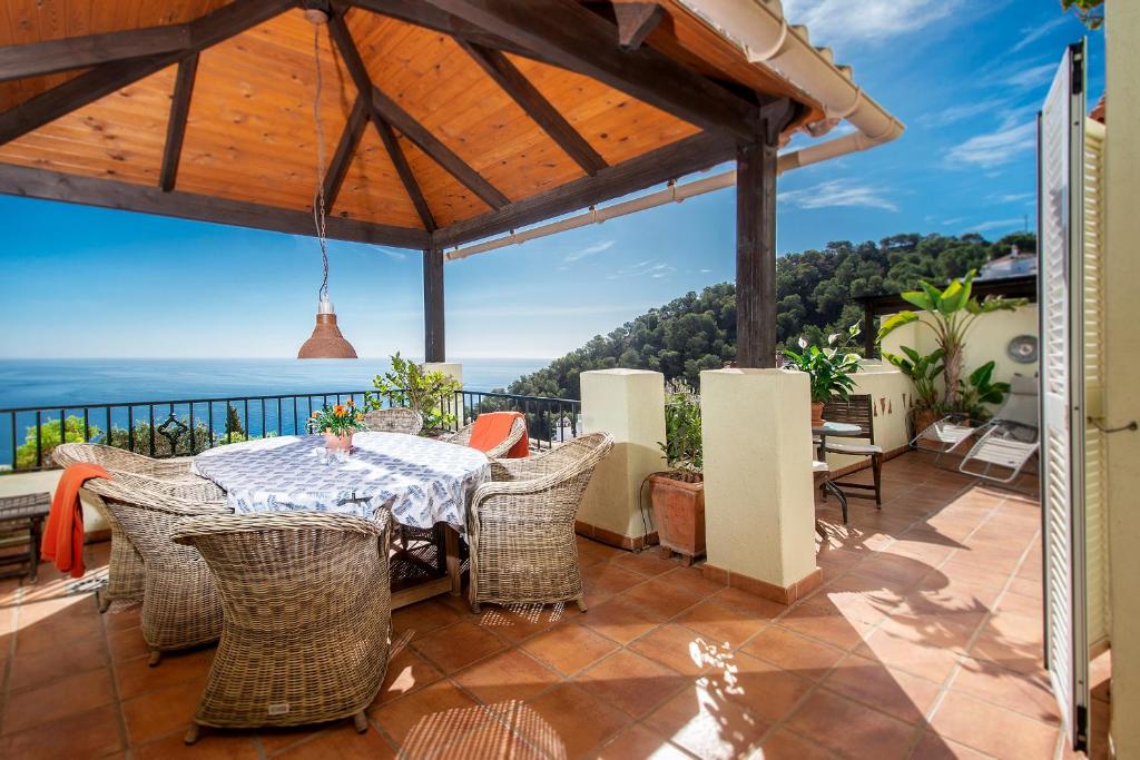 un patio con mesa y sillas y vistas al océano en Casa 11 Vistas, en La Herradura