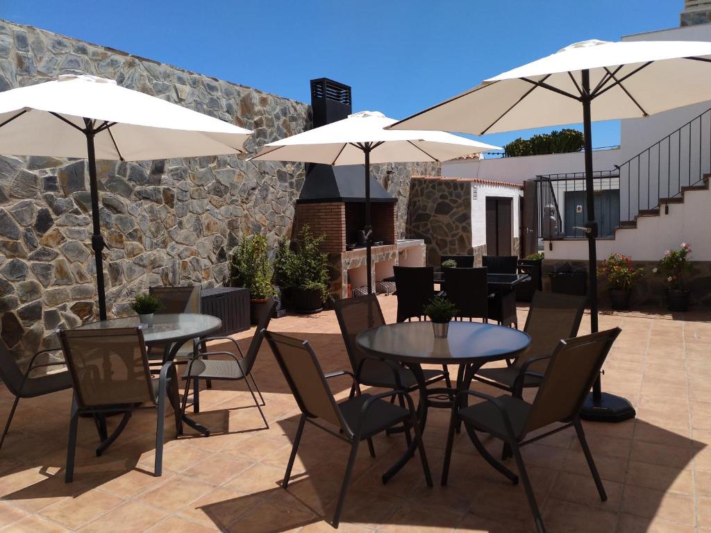 two tables and chairs with umbrellas on a patio at Alojamiento Lo Trabucador in Poblenou del Delta