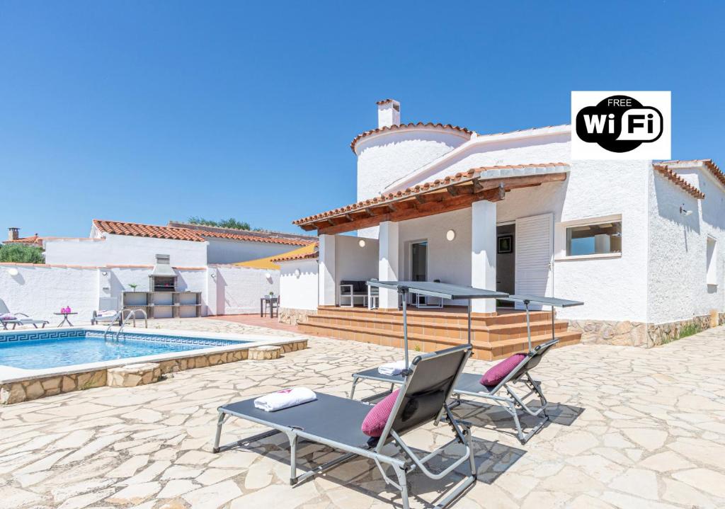 een villa met een zwembad en een huis bij Apart-rent Casa con piscina Alberes 0005 in Empuriabrava