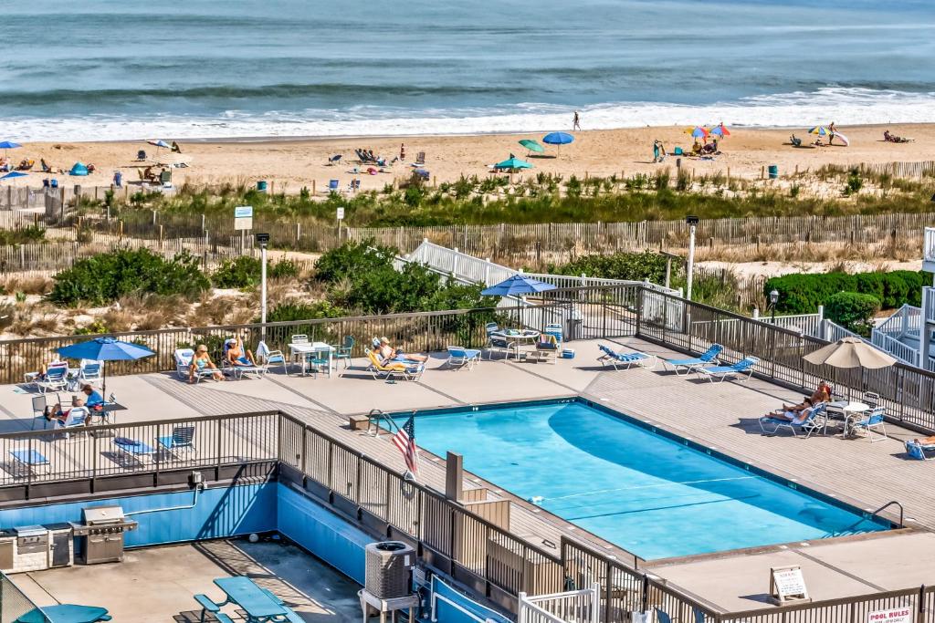 a swimming pool with a beach in the background at Fountainhead Towers in Ocean City