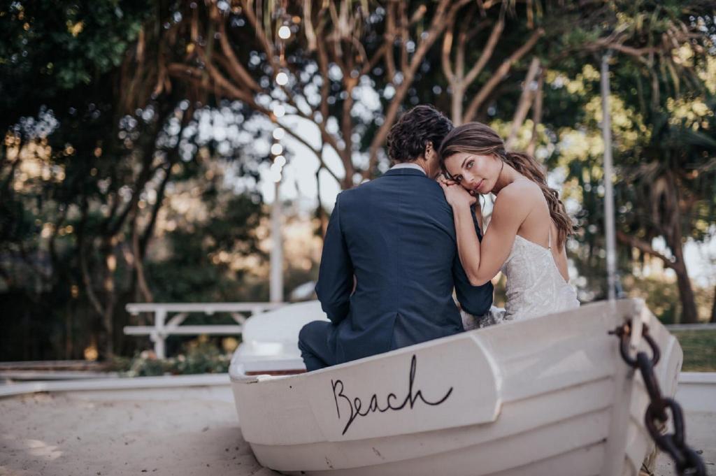a bride and groom sitting in a boat at Hotel Indigo Orange Beach - Gulf Shores by IHG in Gulf Shores