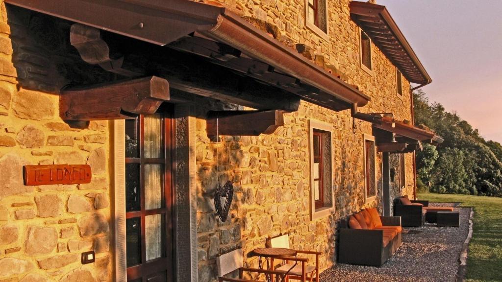 a stone building with a door and a table at Il Lonfo in Pieve Fosciana