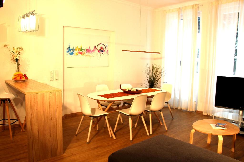 慕尼黑的住宿－Moderne stilvolle Wohnung im Herzen Münchens，客厅设有餐桌和椅子