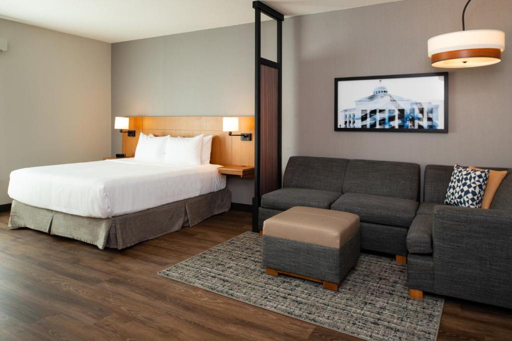 Hyatt Place Dallas/Rockwall في روكوول: غرفه فندقيه بسرير واريكه