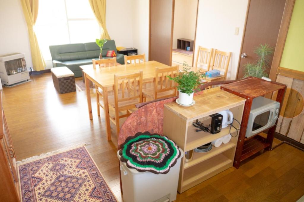 una cucina e un soggiorno con tavolo e forno a microonde di Maeda Forestry House - Vacation STAY 19585v a Furano