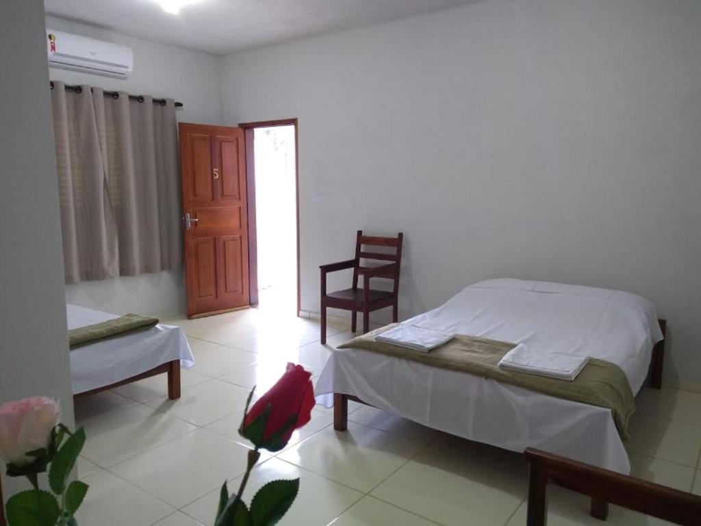 ein Schlafzimmer mit einem Bett und einem Stuhl darin in der Unterkunft Pousada Sol de Minas in Monte Sião