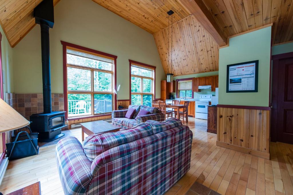 een woonkamer met een bank en een fornuis bij Gîte du Mont-Albert - Sepaq in Sainte-Anne-des-Monts