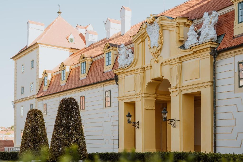 un bâtiment avec des arbres devant lui dans l'établissement Zámecký Hotel ANTON FLORIAN, à Valtice