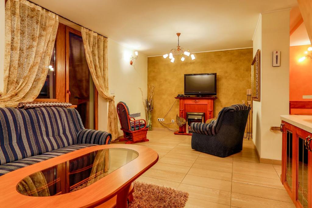 a living room with two couches and a tv at Wellness Apartmány Fatrapark 1 Malinô Brdo in Ružomberok