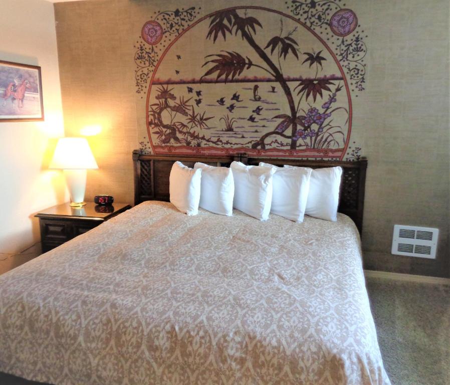 a hotel room with a bed with white pillows at The Polynesian Resort in Ocean Shores