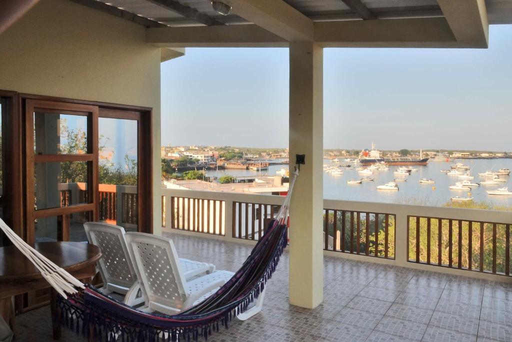 a porch with a hammock and a view of a harbor at The Galeodan Suites in Puerto Baquerizo Moreno