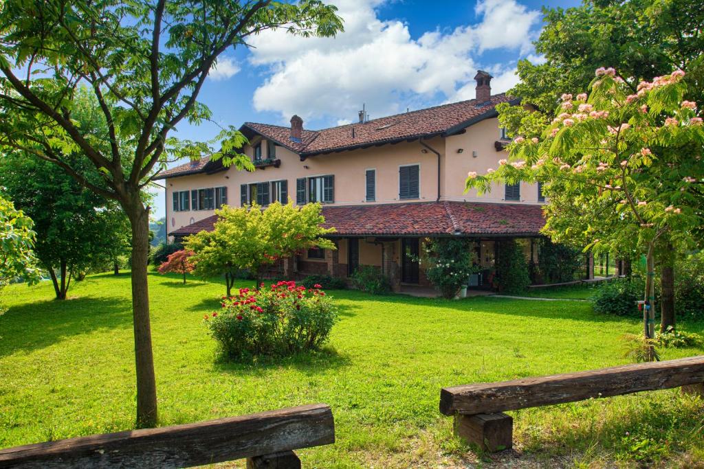 une grande maison avec un banc devant elle dans l'établissement Cascina Papa Mora, à Cellarengo