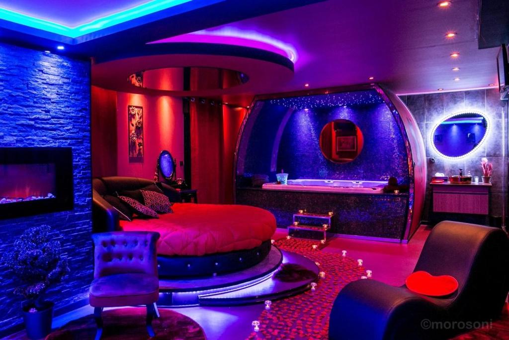 um quarto com uma cama num quarto com luzes roxas em L'Insolite Spa Privatif ''Suite Luxueuse-Jacuzzi" em Toulouse