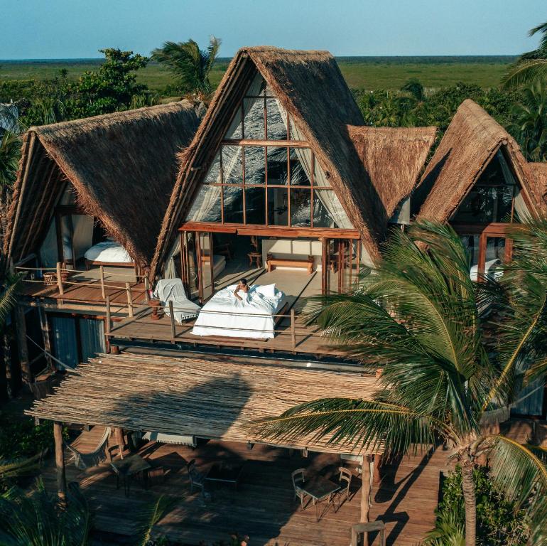 uma vista aérea de uma casa com telhado de palha em La Valise Tulum em Tulum