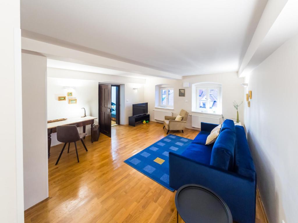a living room with a blue couch and a table at Stairway to the castle in Ljubljana