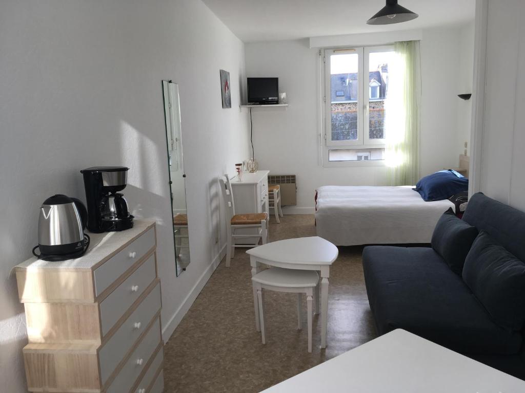 a living room with a couch and a bed and a table at Studio cocooning in Saint Malo