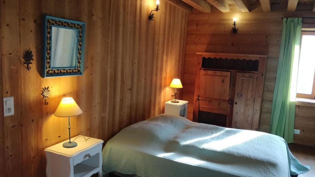 a bedroom with a bed and two lamps in it at Chalet Du Vieux Guide in Samoëns