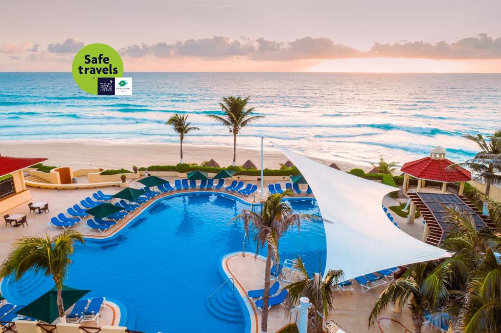 a view of a resort with a pool and the ocean at GR Solaris Cancun All Inclusive in Cancún