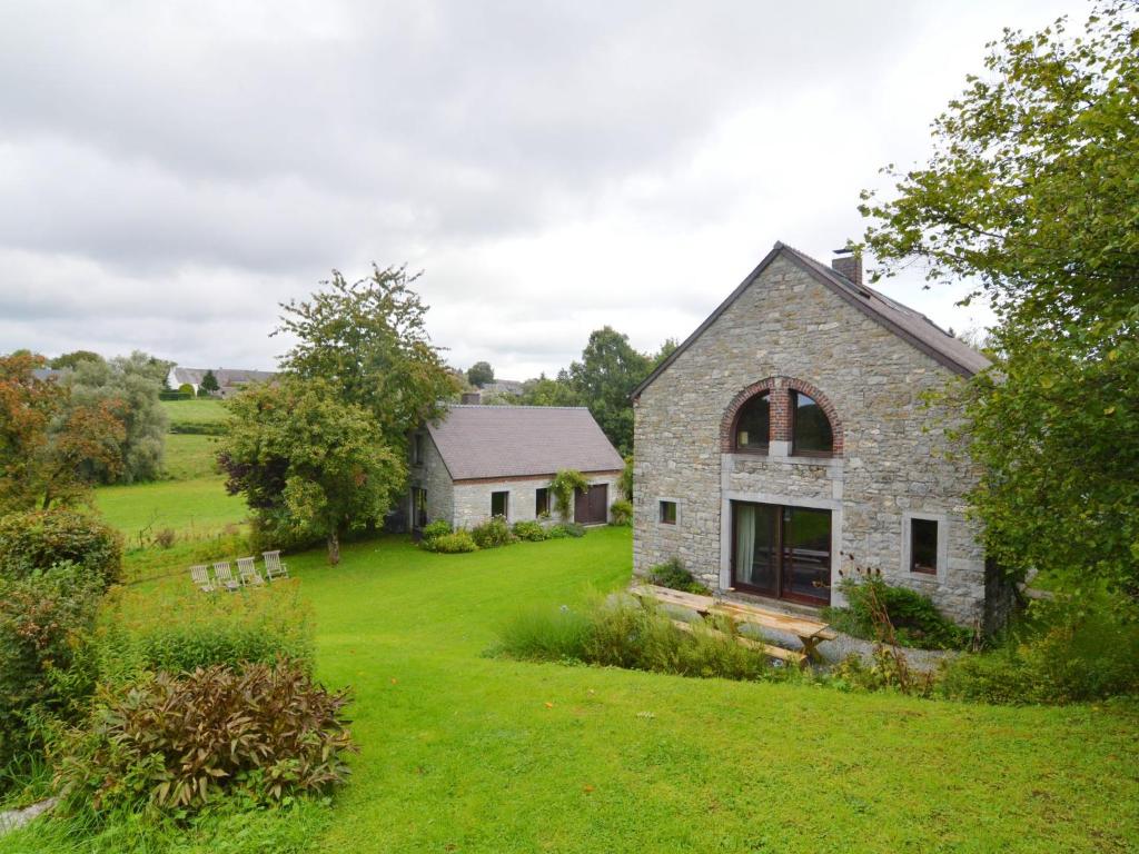 an old stone house with a green yard at Quaint Holiday Home in Robechies amid Meadows in Chimay