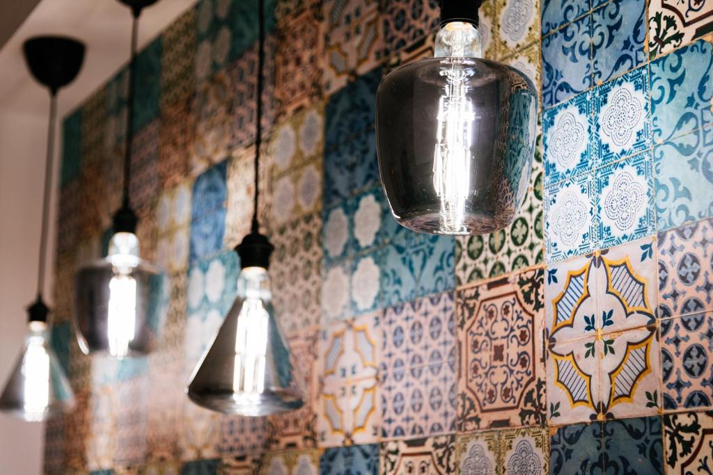 a group of lights hanging from a tiled wall at Casa Aragona b&b in Capua