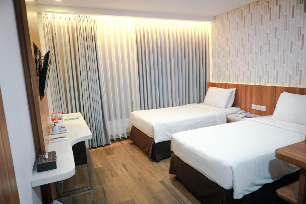 Postel nebo postele na pokoji v ubytování Harmoni Hotel Garut