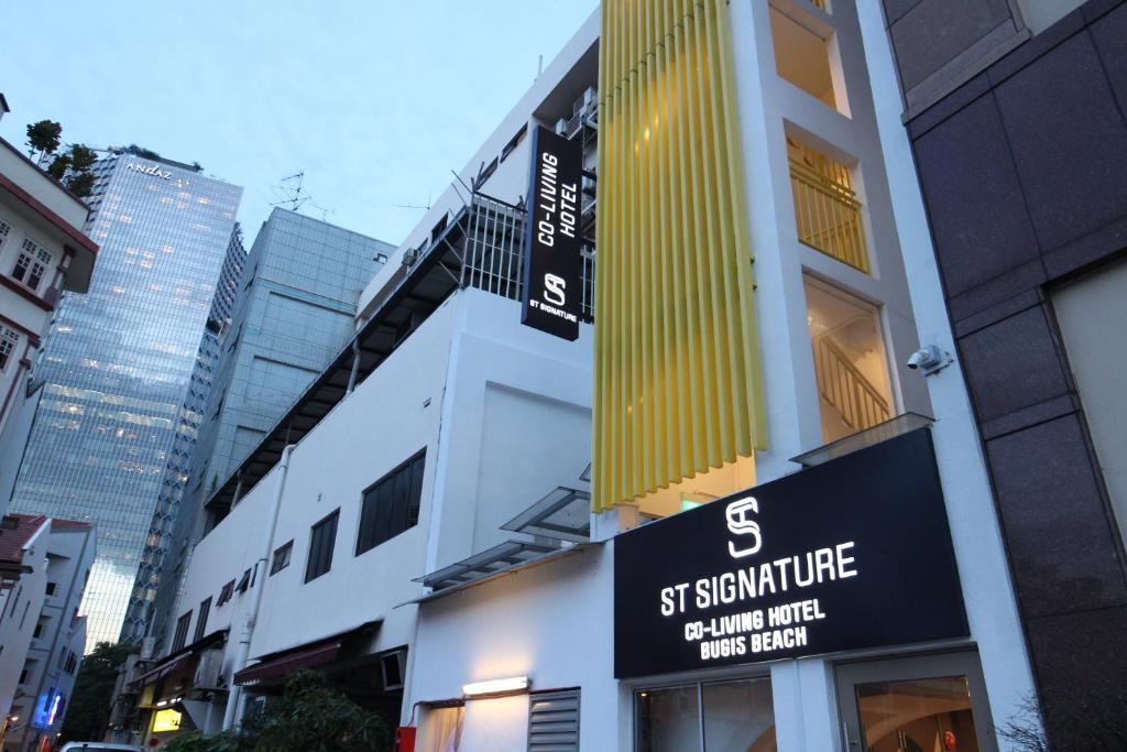 ein Gebäude mit einem Schild an der Seite in der Unterkunft ST Signature Bugis Beach, DAYUSE, 8-9 Hours, check in 8AM or 11AM in Singapur