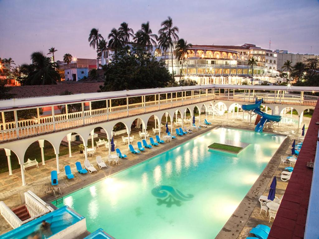 a swimming pool with a bridge and a train at Collection O Hotel Mocambo, Boca del Río in Veracruz