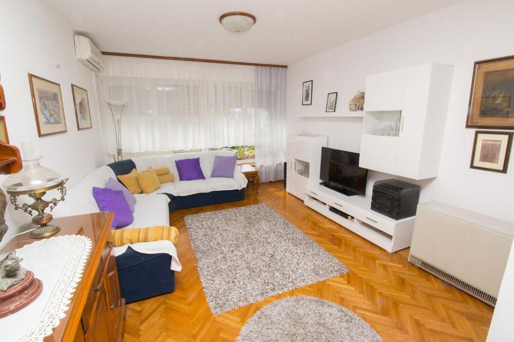 een woonkamer met een bank en een tv bij Apartment Jerko - 200 m from beach in Omiš