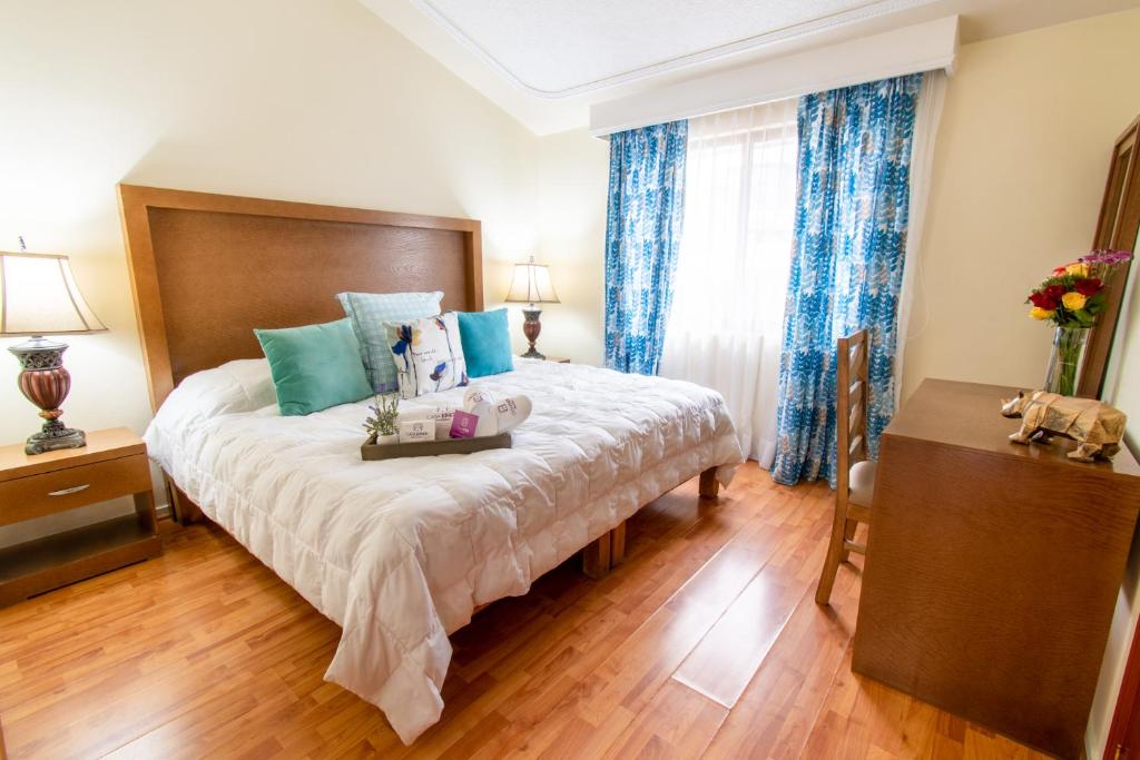 um quarto com uma cama grande e cortinas azuis em Casa Kinich em Guadalajara