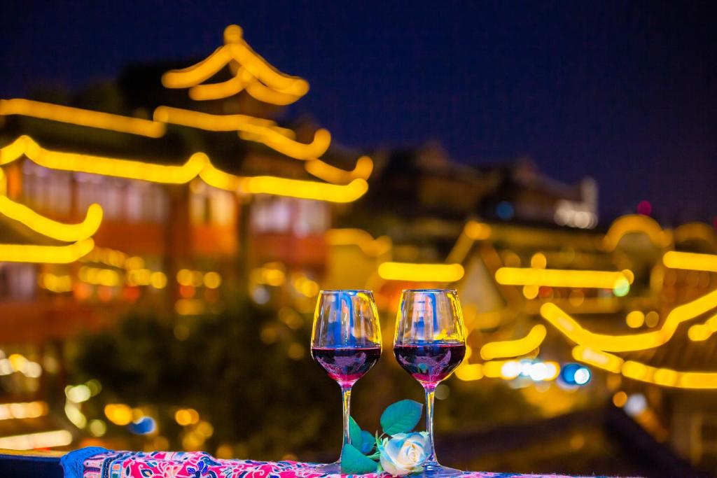 two wine glasses sitting on top of a table at Wenjun Courtyard Hotel Chengdu ( Kuanzhai Branch) in Chengdu
